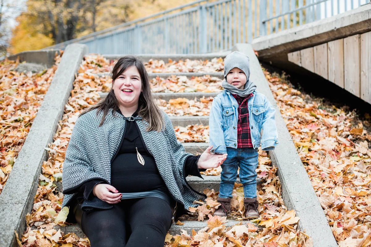 Mom wearing fall cape taking photo with son