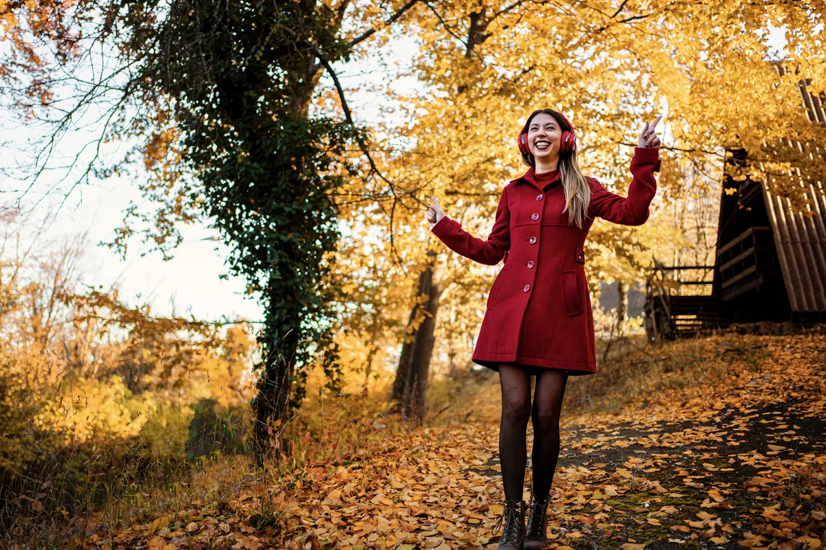 Woman in autumn wearing red coat and black tights