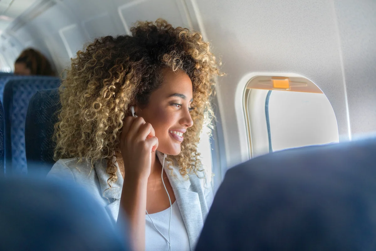 Woman with headphones on a plane