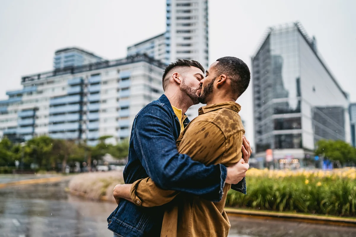 couple standing on city street in the rain