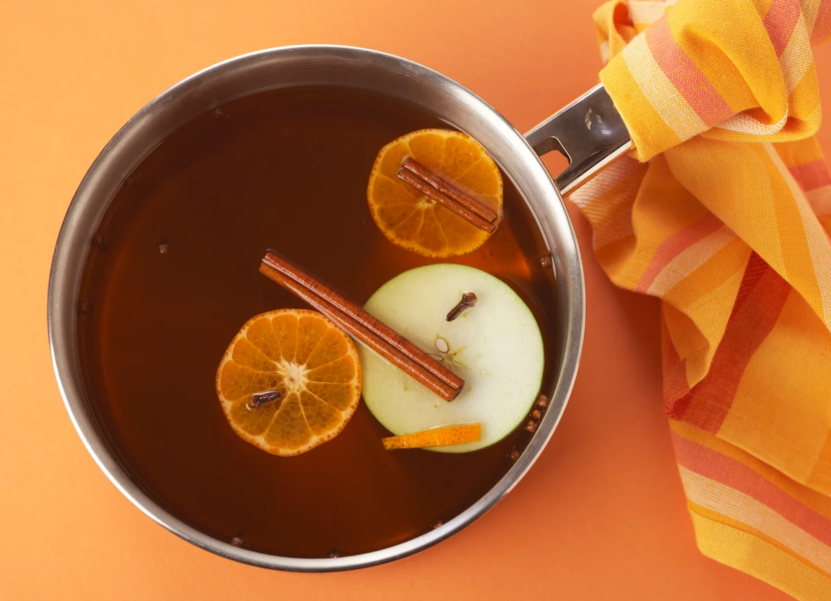 Pot with apple and orange slices and cinnamon