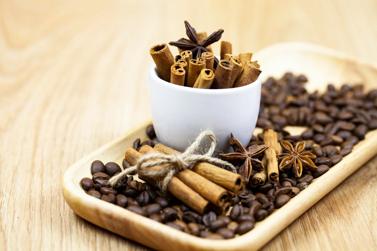 Coffee beans and cinnamon sticks on a tray
