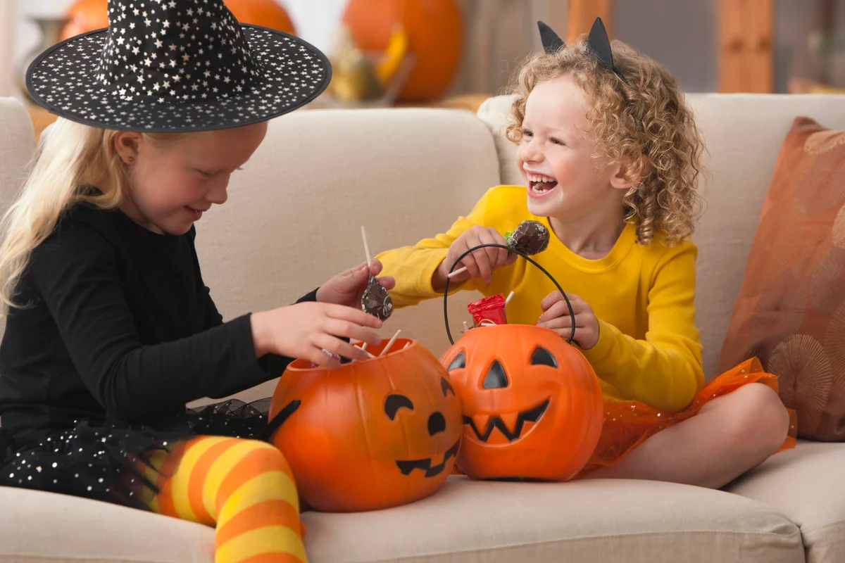 Girls in Halloween costumes eating candy