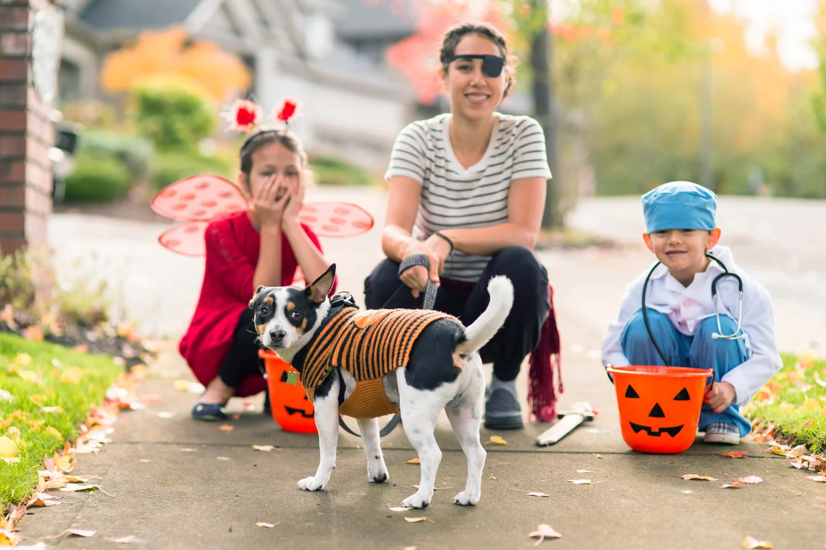 Family in Halloween costumes with their dog