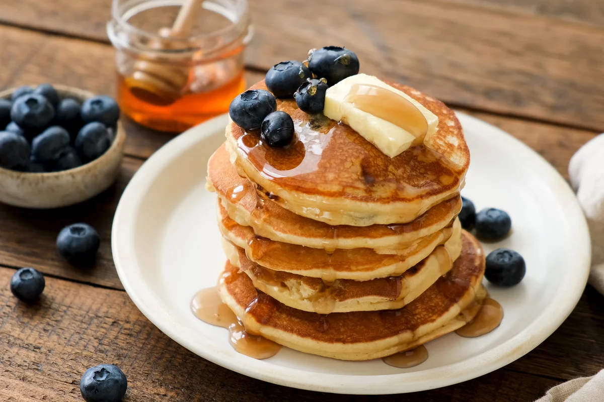 Breakfast pancakes with blueberries, butter and honey