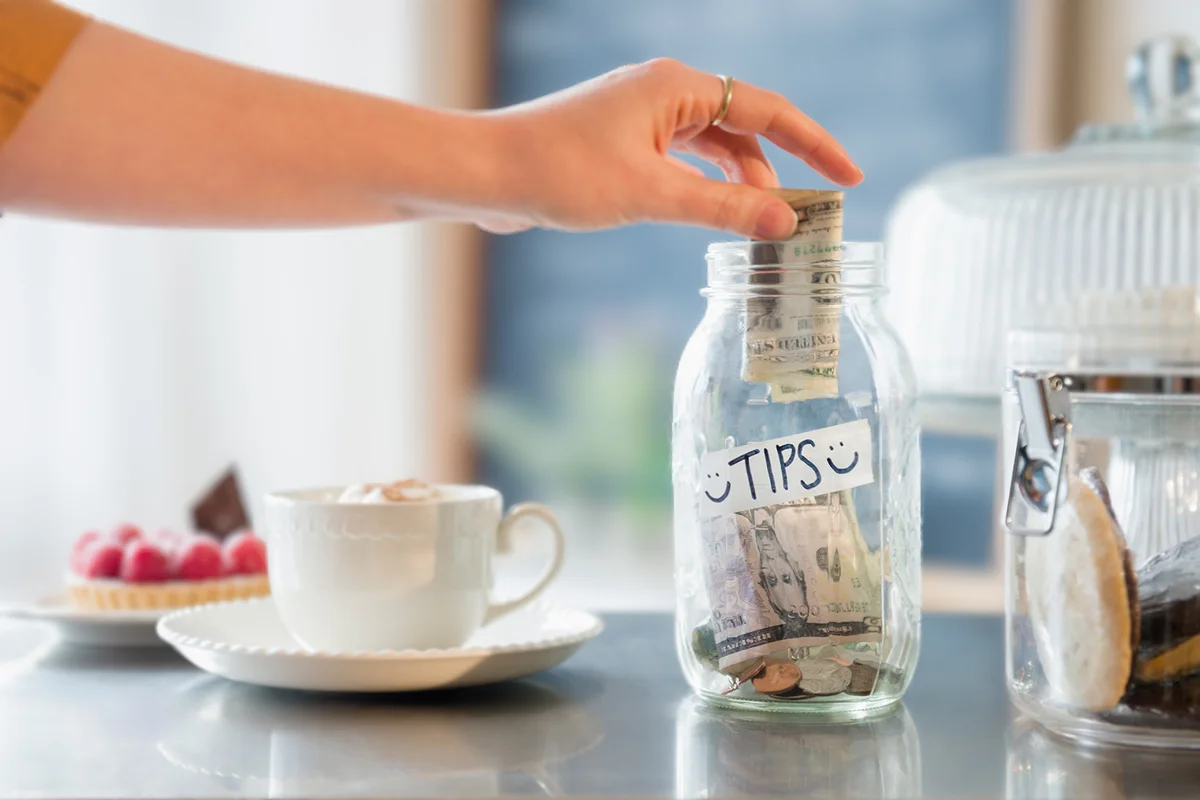 Caucasian woman putting money in tip jar
