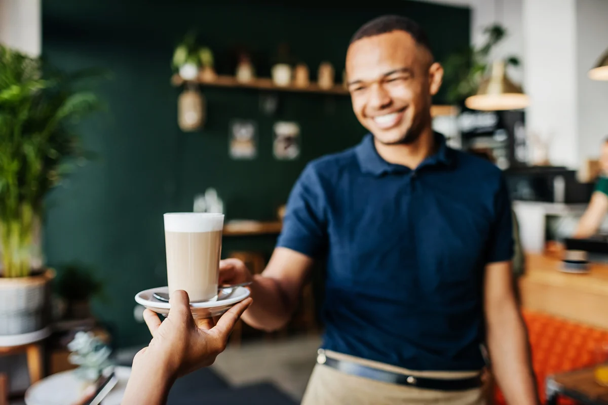 Close Up Of Latte Being Given To Customer