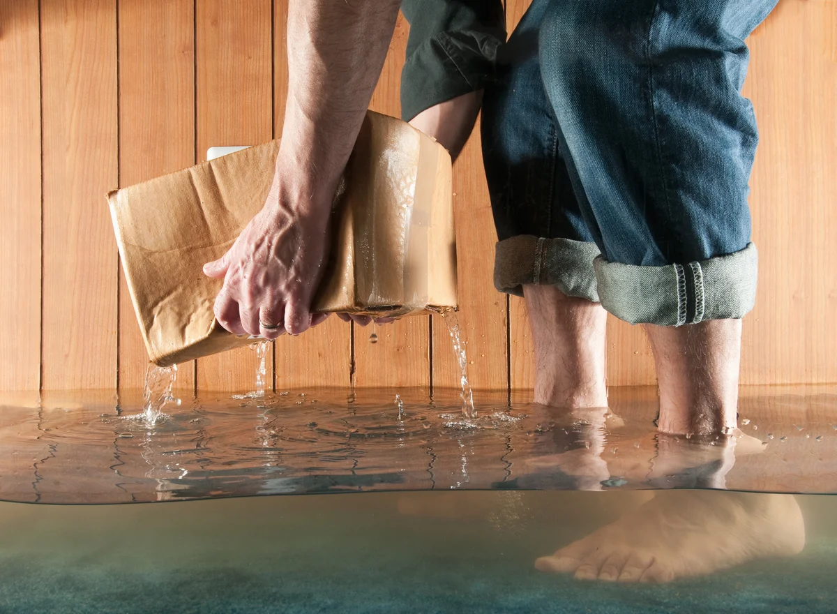 Person picking a box out of flooded water