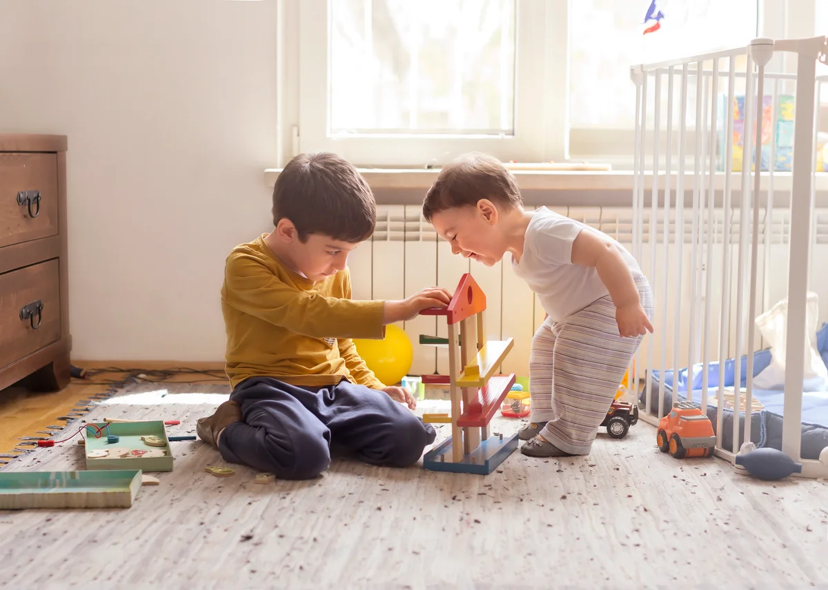 Young boy playing with his 1 year old sibling