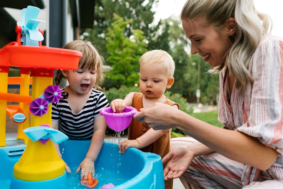 Mom playing with baby and daughter in water