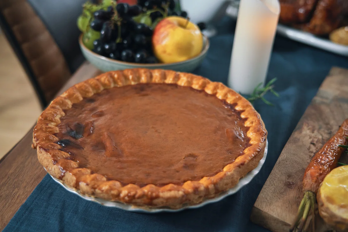 Pumpkin pie and apples decorating a table