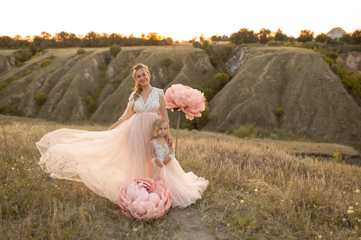 Woman and daughter wearing matching blush wedding dresses