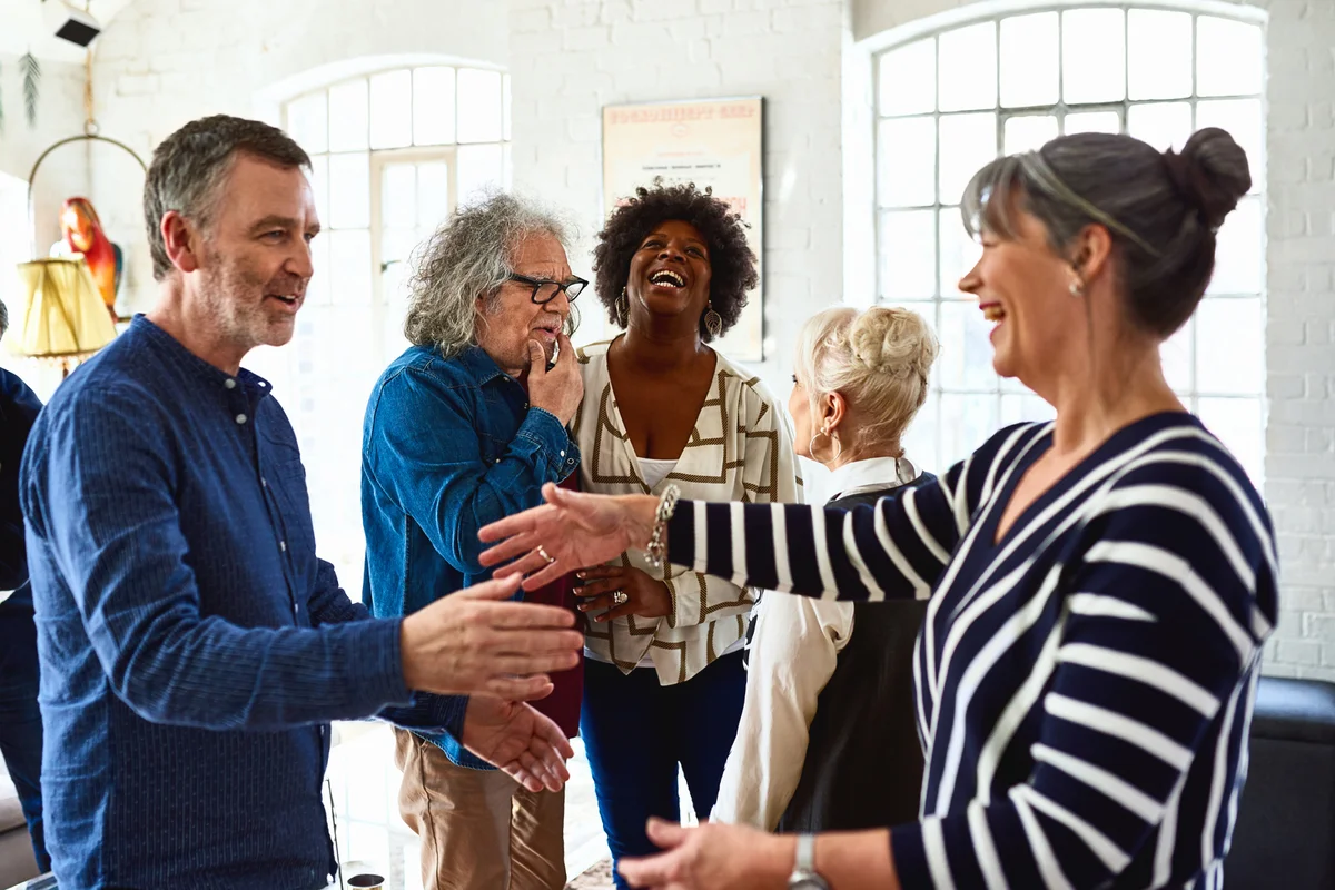 Mature friends greeting each other at social gathering