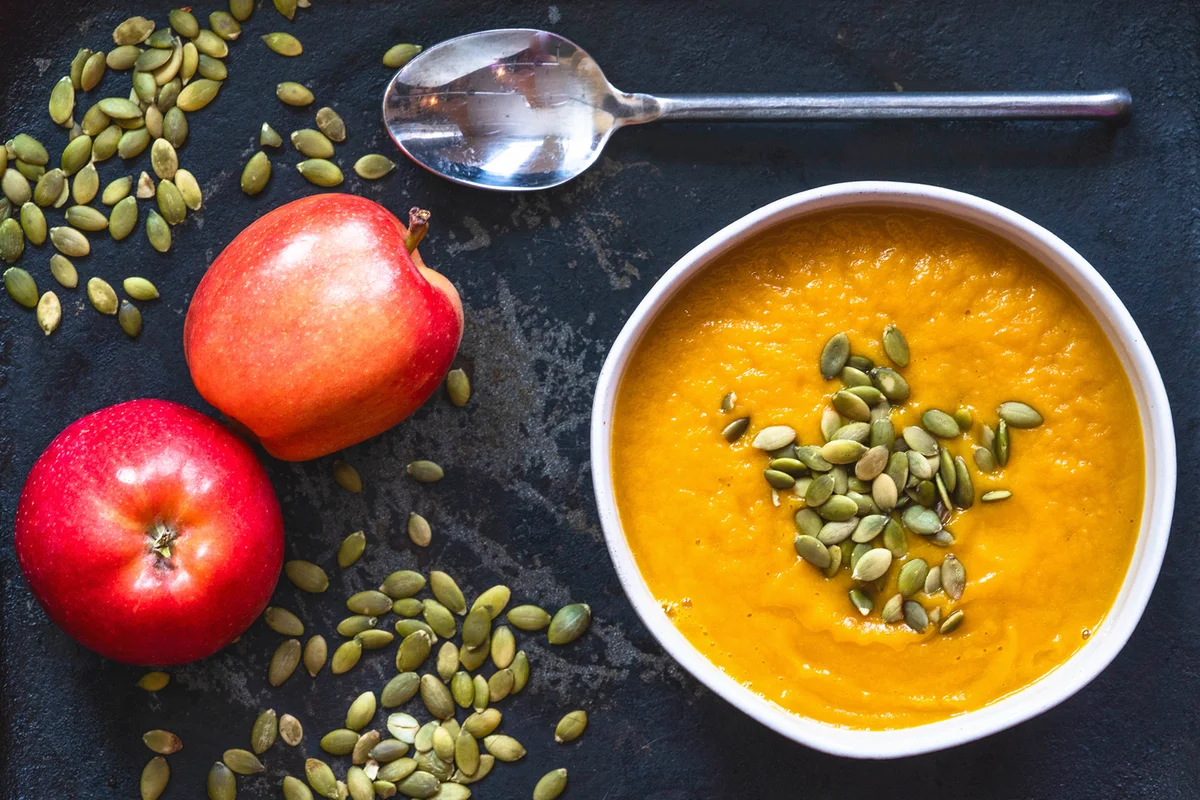 Winter squash soup with apples on a table.