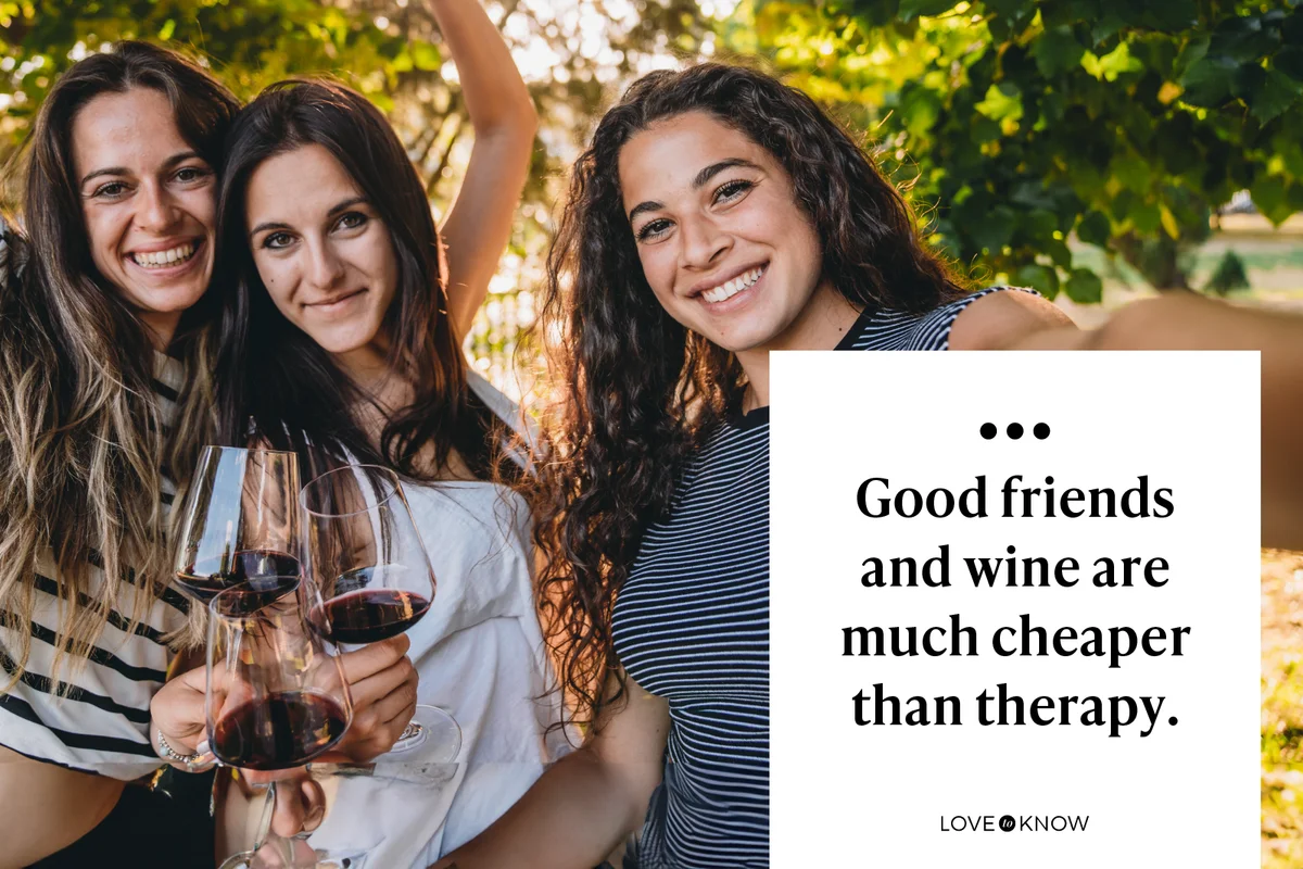 Three young adult friends are toasting with a glass of red wine while they are taking a selfie