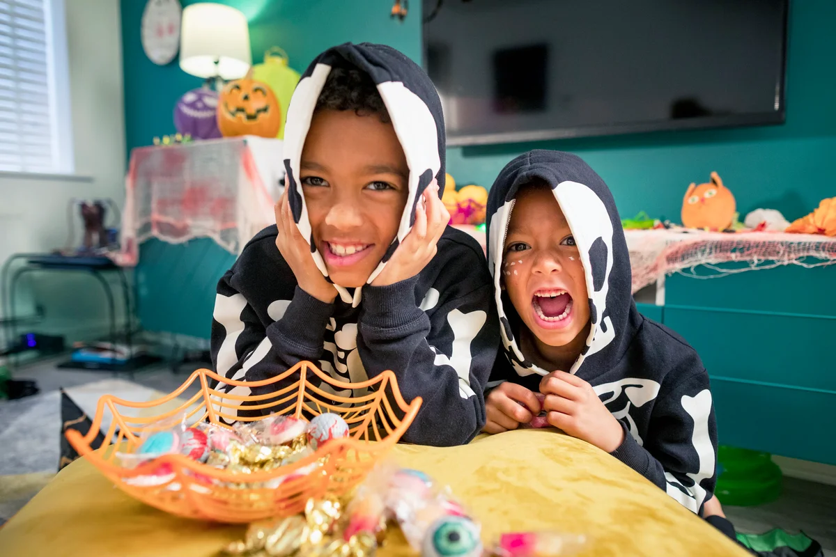 Two young brothers wearing matching skeleton costumes for Halloween party
