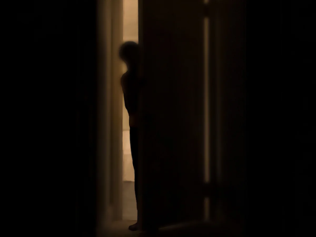 person peeking into a spooky room