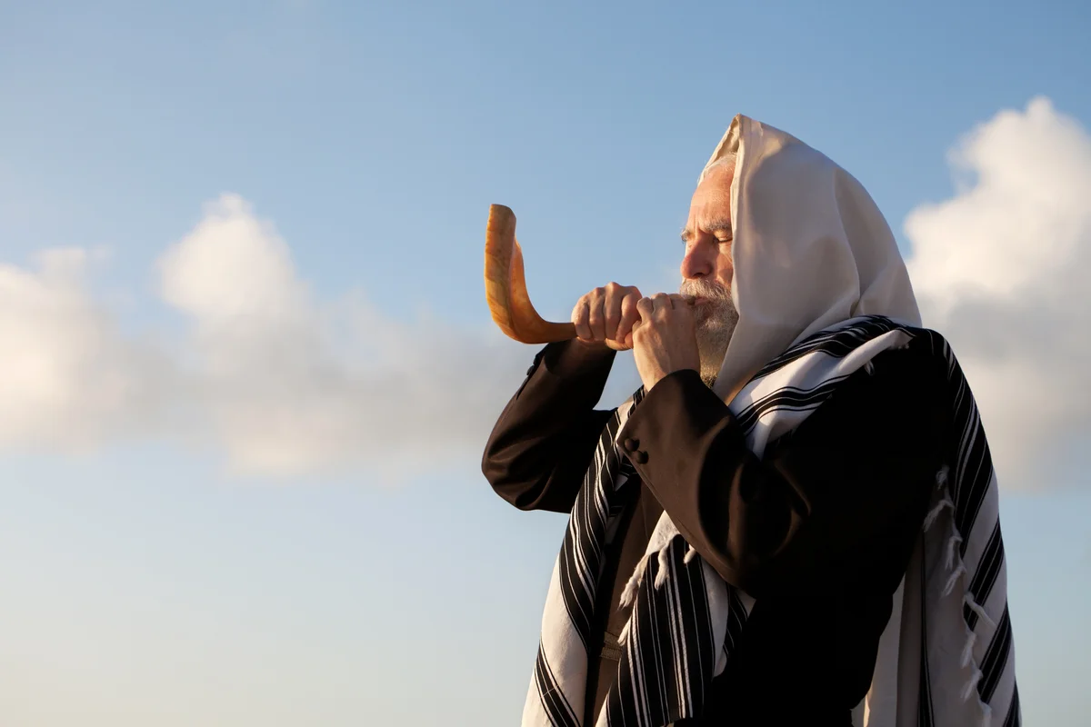 man blowing a shofar