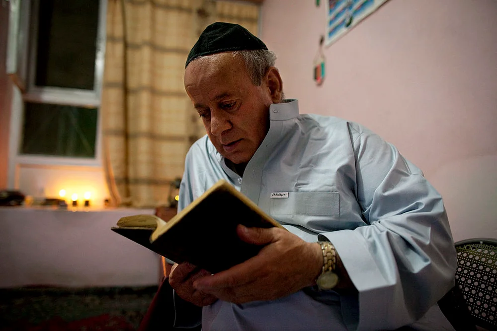KABUL, AFGHANISTAN - SEPTEMBER 18: Zebulon Simantov reads his old tatered hebrew prayer book as he celebrates the Jewish New Year feast of Rosh Hashanah September 18, 2009 in Kabul, Afghanistan. Zebulon, 57, claims to be the last Jew living in the war-torn conservative Muslim country and says he keeps a Kosher home. The Jewish New Year, or Rosh Hashanah, coincides this year with Eid al-Fitr, a Muslim feast marking the end of the fasting month of Ramadan. Born in northwestern Herat, Simantov attended Hebrew school before moving to Kabul at age 27. In 1992, he fled to Tajikistan, fleeing from Afghanistan's growing violence, married a Tajik Jew and had two daughters. The family immigrated in 1998 to Israel, but he returned to Kabul two months later, leaving them behind.