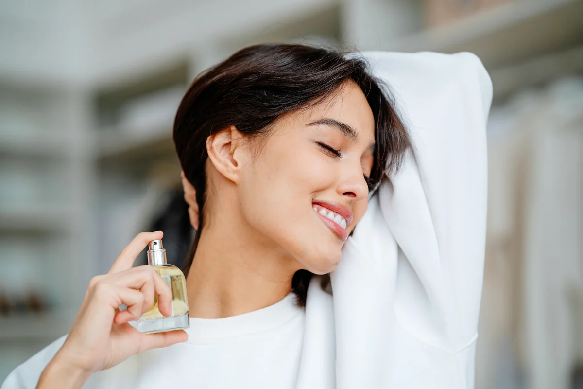 Woman spraying herself with perfume