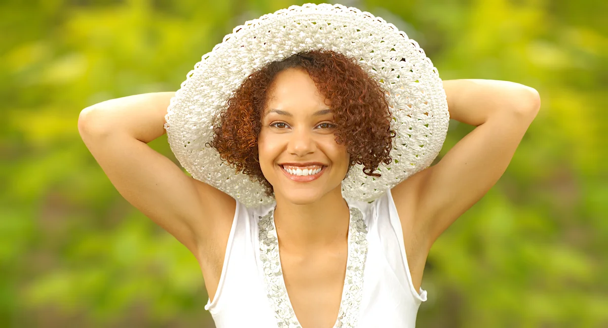 Girl with naturally curly short hair and a cute sunhat