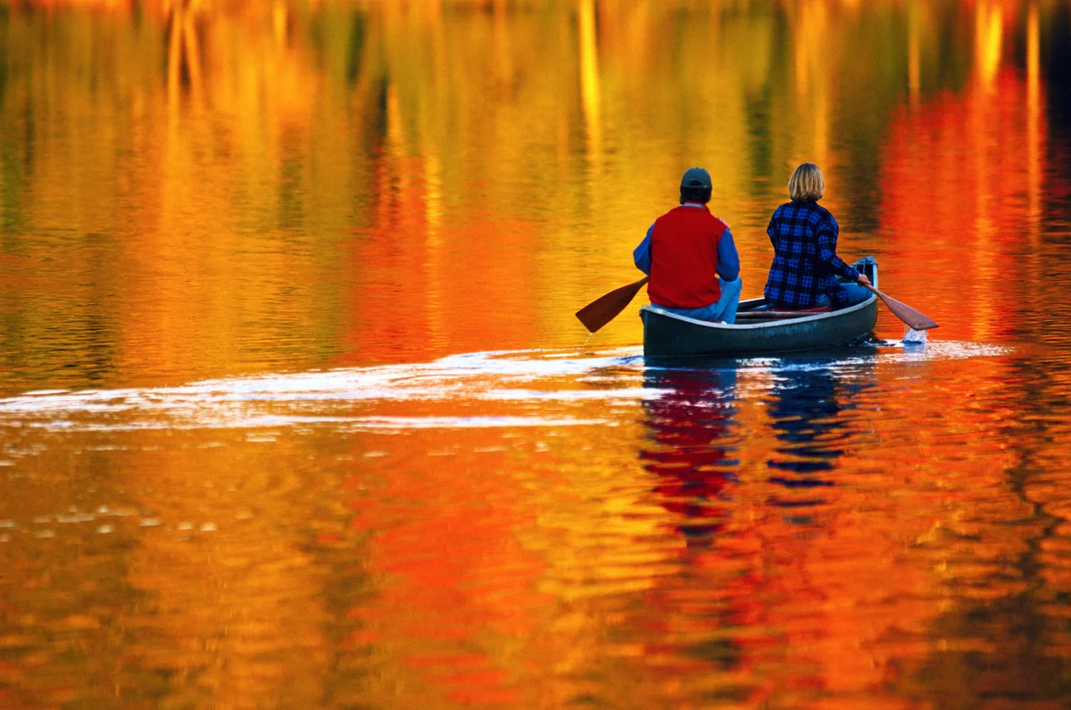 couple canoeing on the lake in autumn