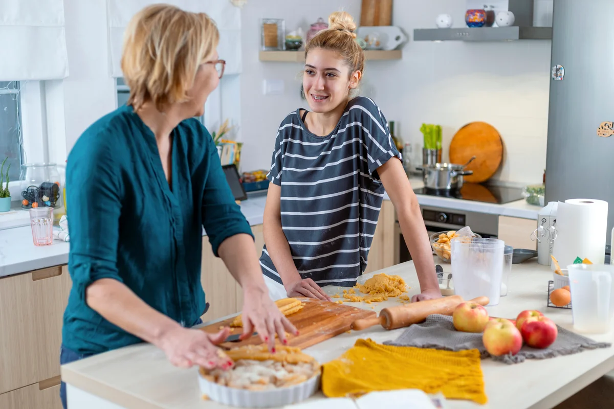 Mom and teen daughter making apple pie