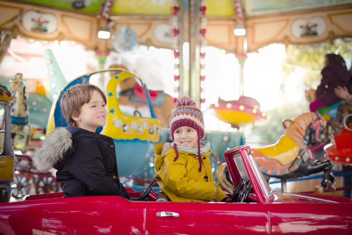 Kids smiling and riding the carousel
