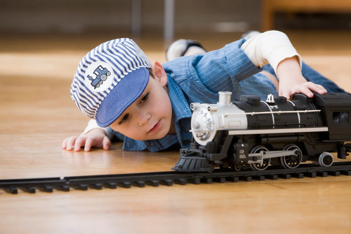 Young boy playing with toy trains