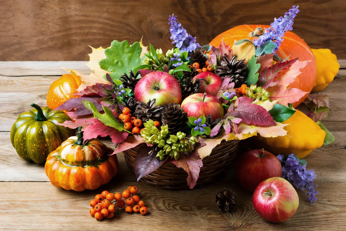 Fall arrangement with blue flowers and seasonal fruits