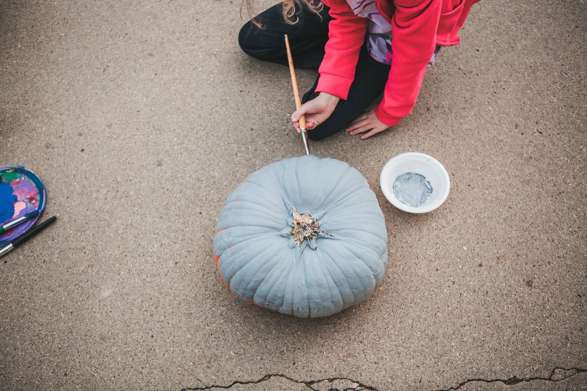 Child painting a pumpkin