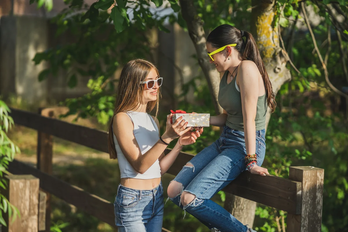 Girl giving her girlfriend a gift box