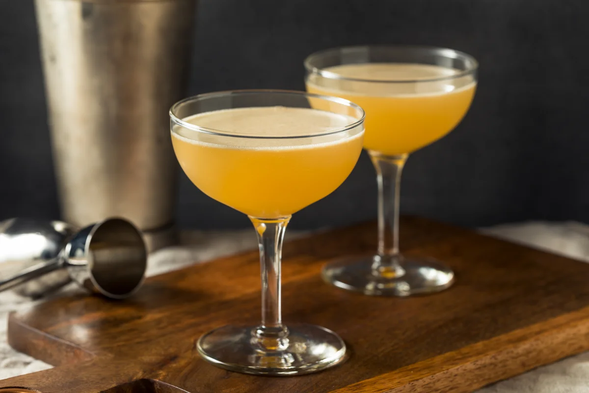 Two coup glasses of fig bees knees cocktails