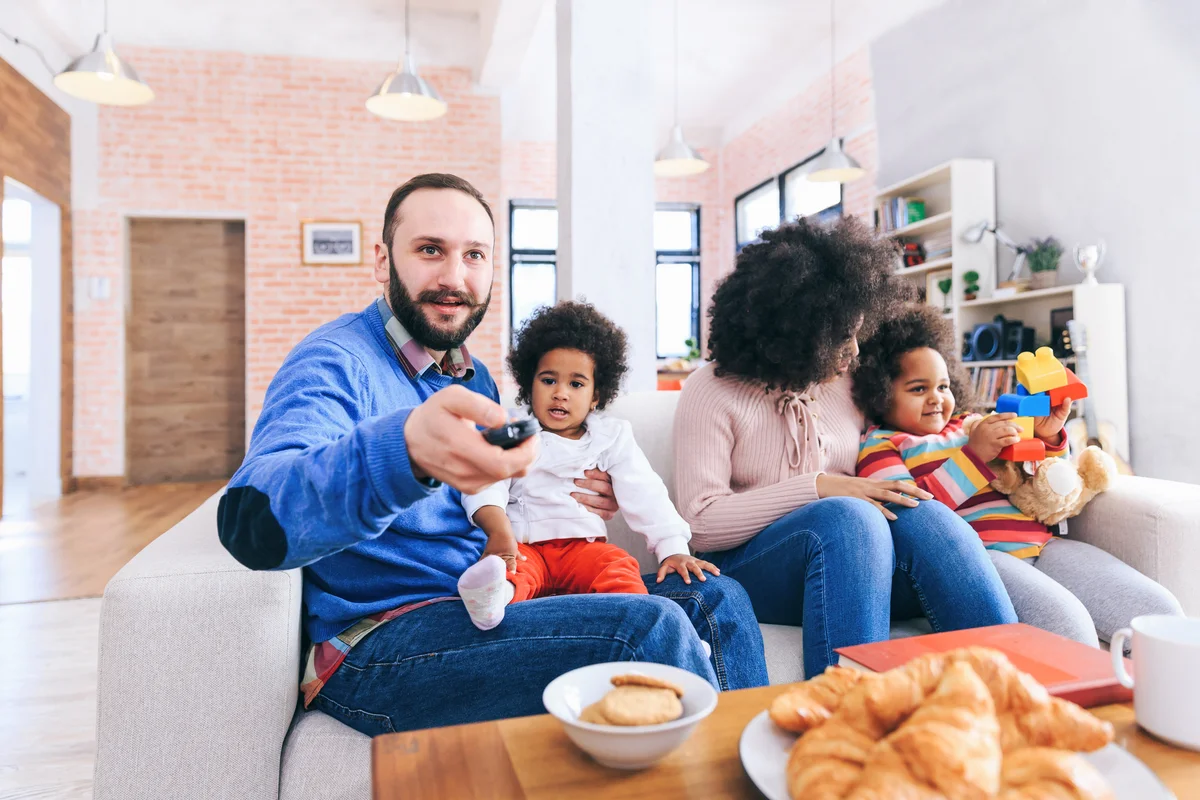 Family attempting to watch tv with young kids