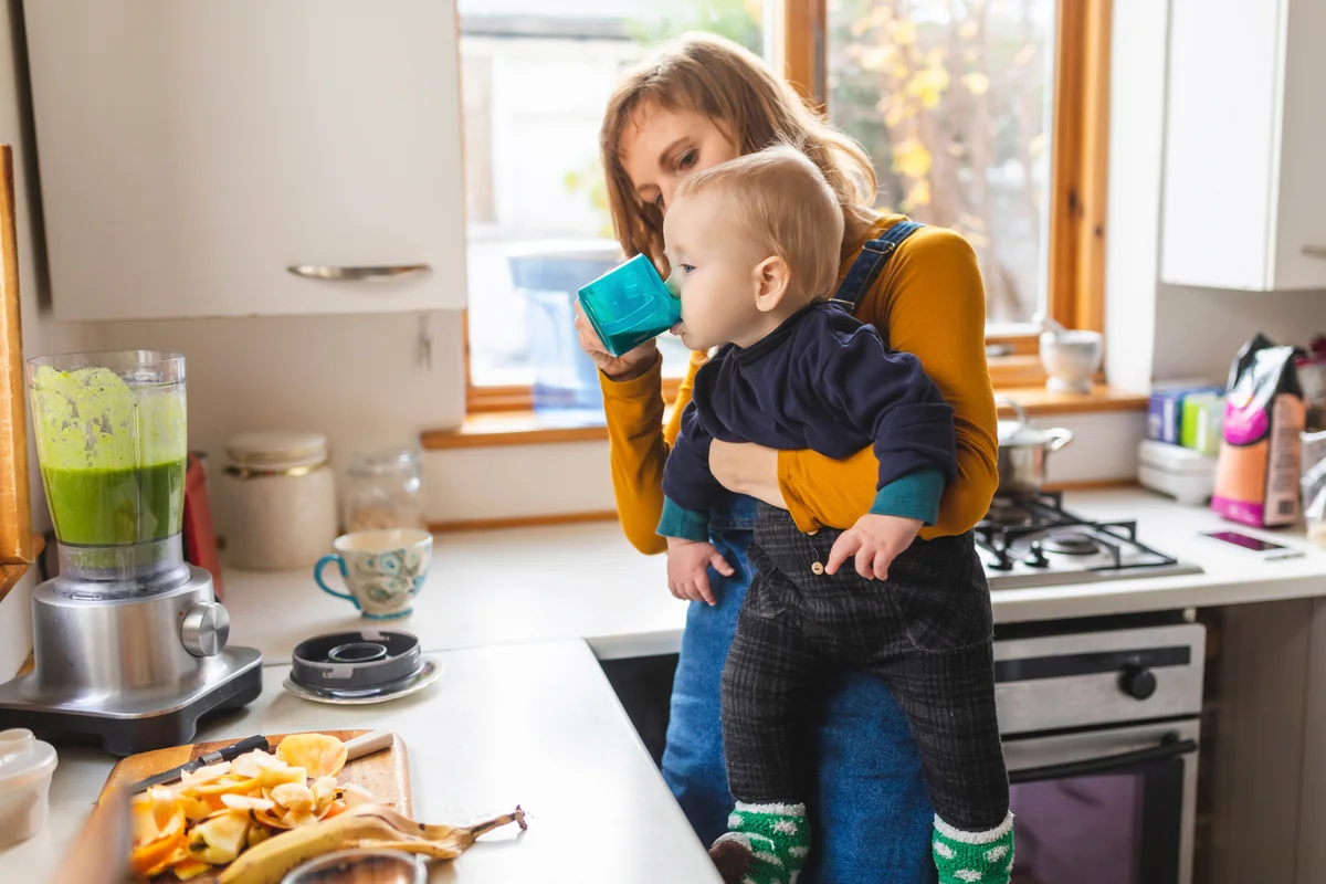 Mom giving baby a sip from her cup