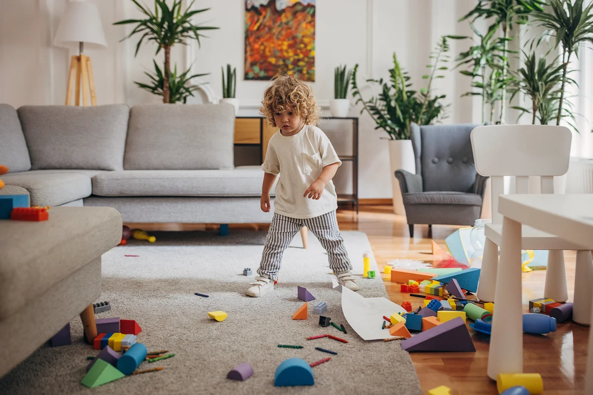 Young child standing in messy living room