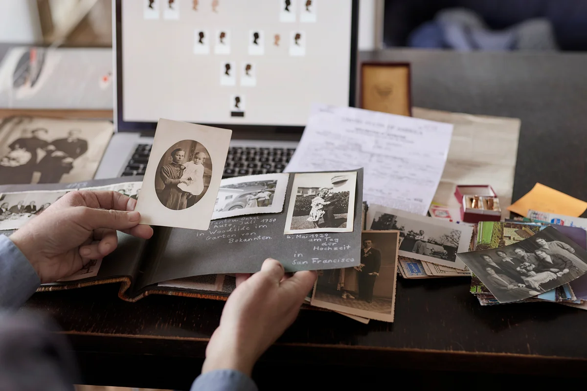 person looking through antique photograph collection