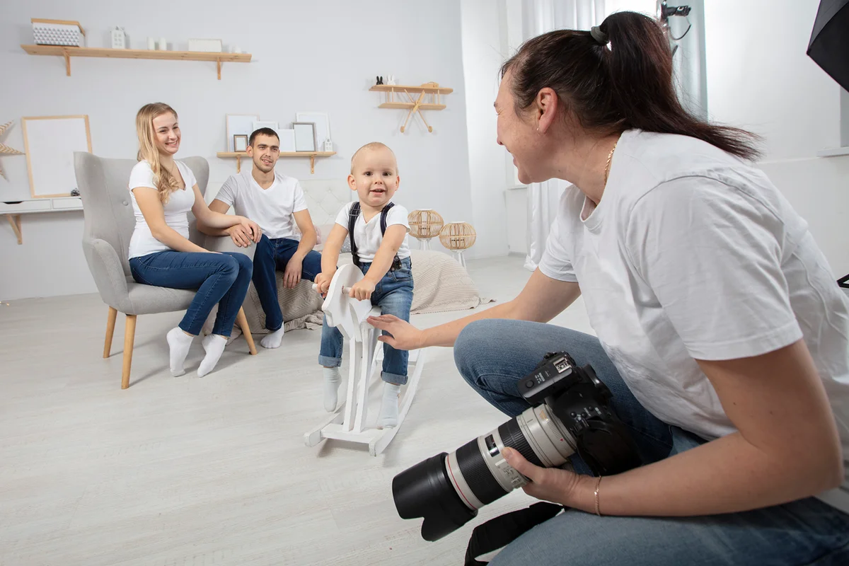 A photographer photographs a family in a photo studio