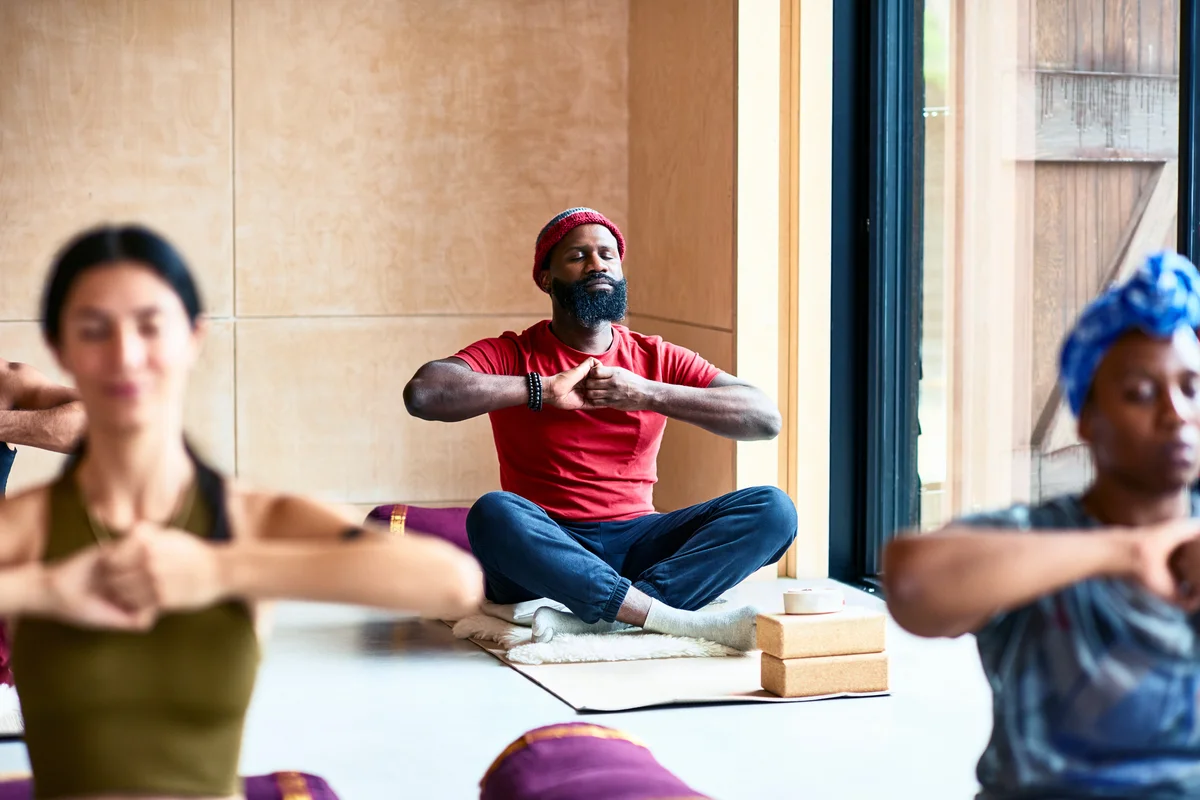 Man in yoga pose with hands clasped