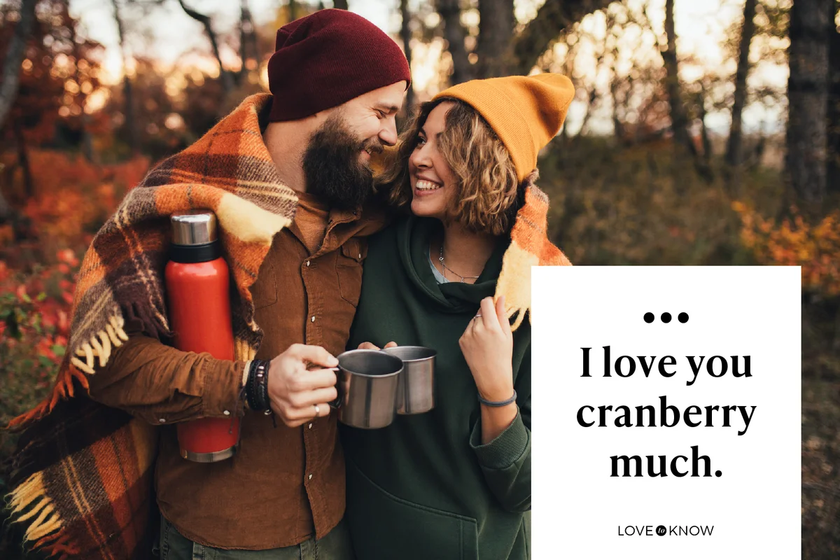 Happy couple in love drinking tea from thermos in beautiful autumn forest