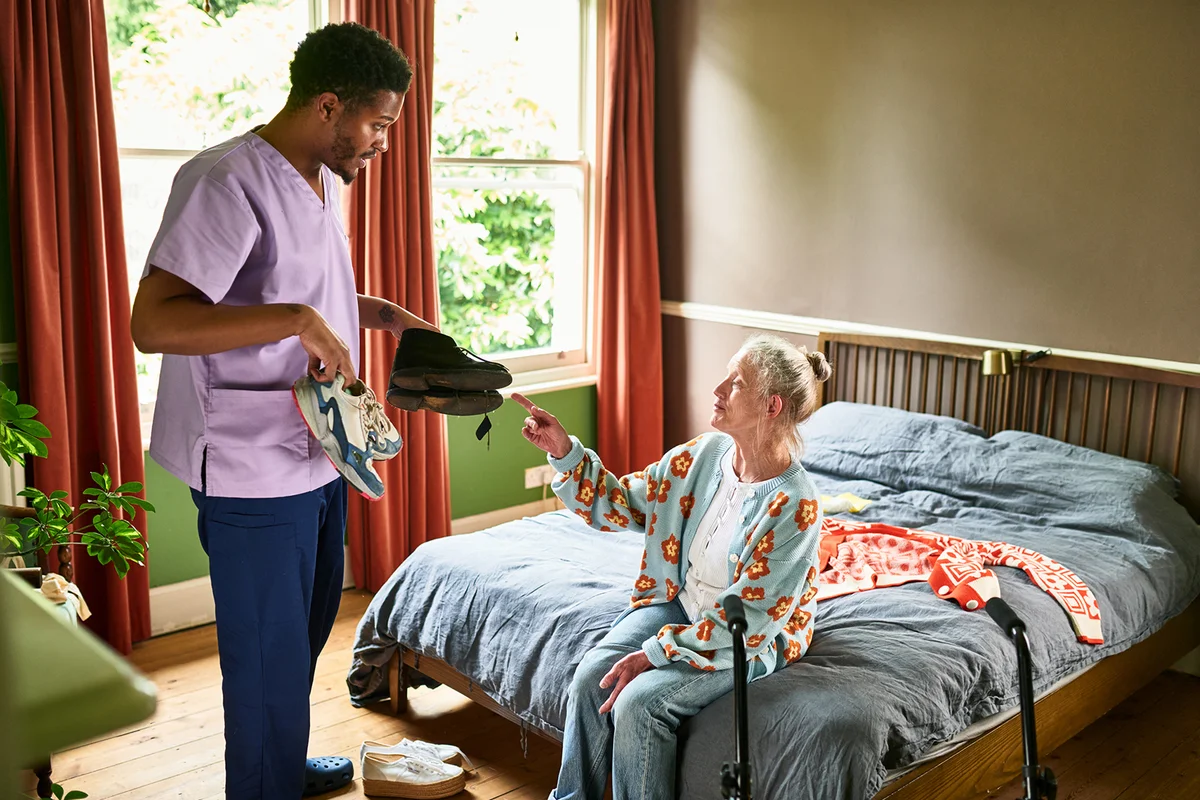 Senior woman choosing what shoes to wear in care home
