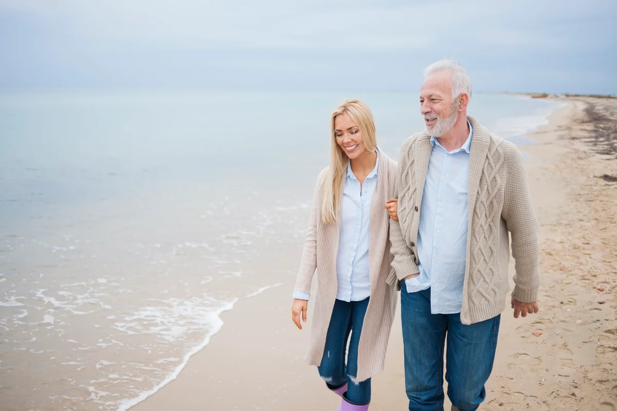 father and daughter walking on beach