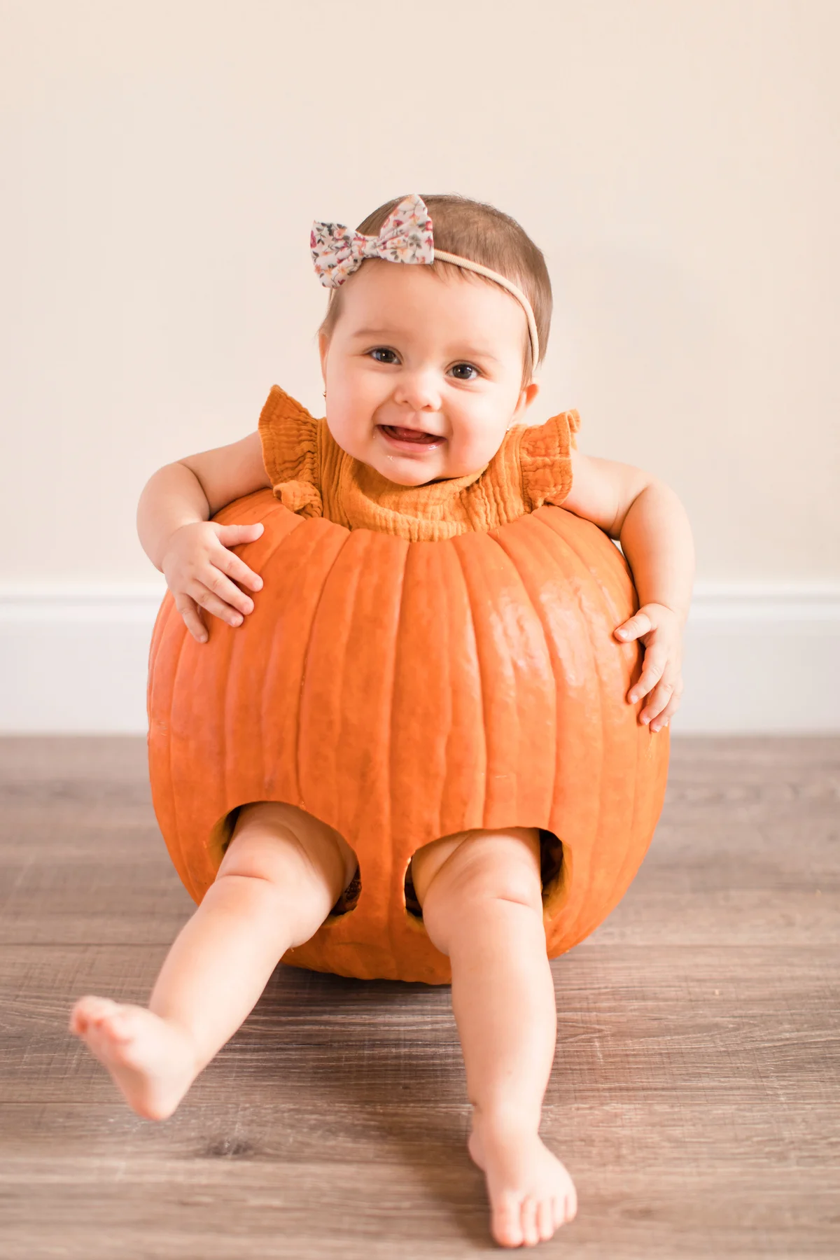 Baby girl inside a large orange Pumpkin