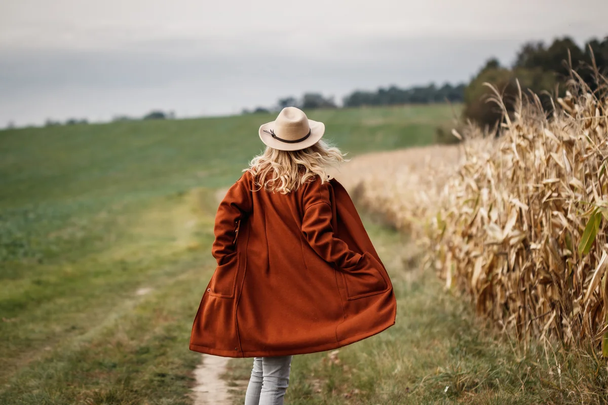 woman in field with terracota jacket