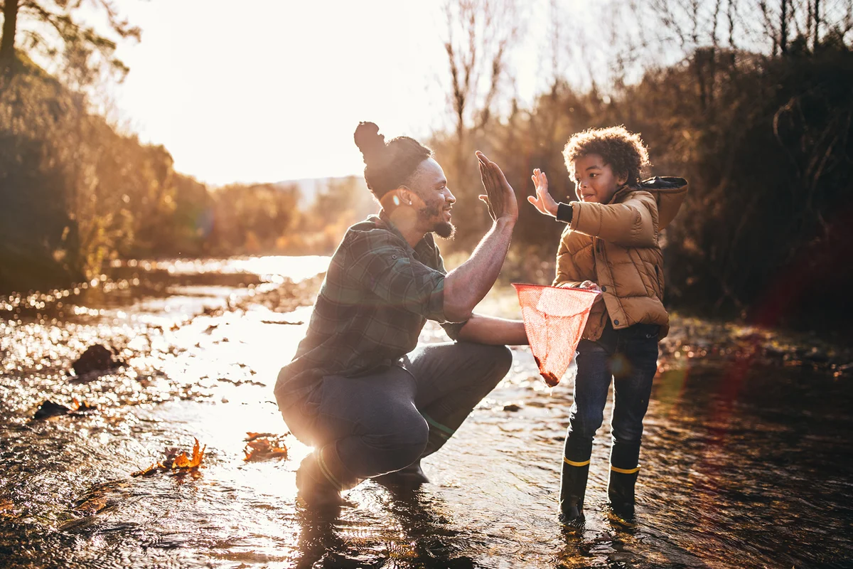 Successful father and son catching fish and doing high five