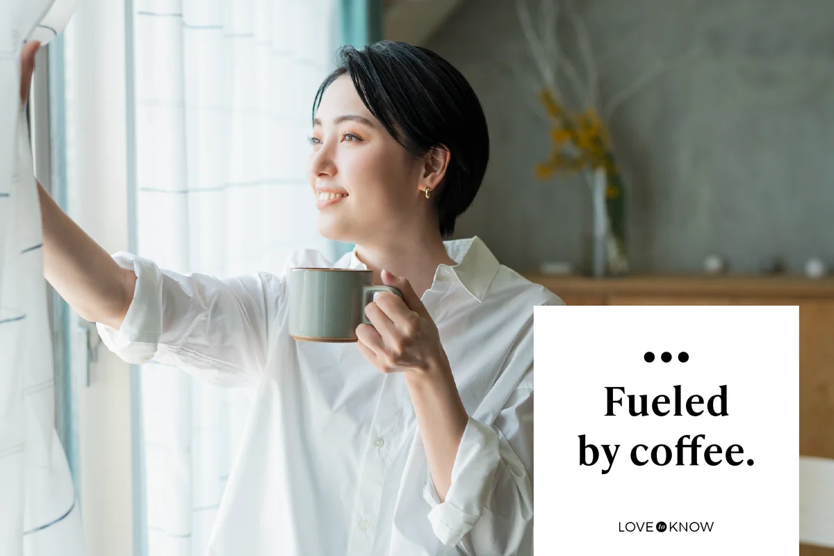 A woman drinking coffee by the window