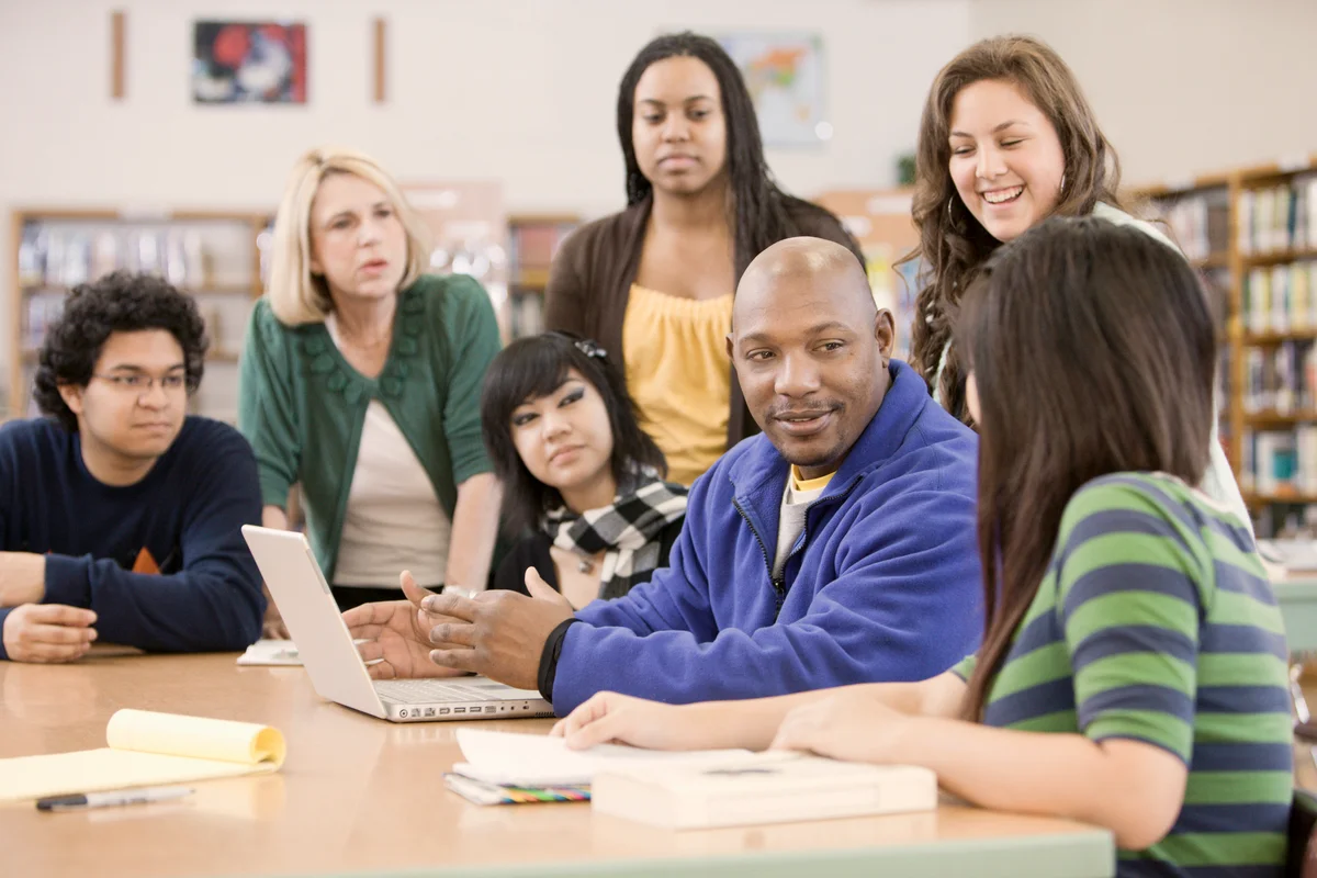 Librarian helping students in school library