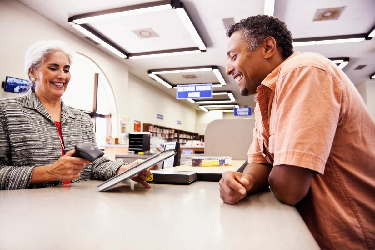 Man checking out book from library