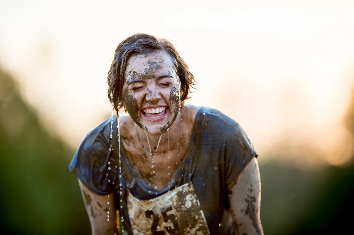 Woman in mud run smiling