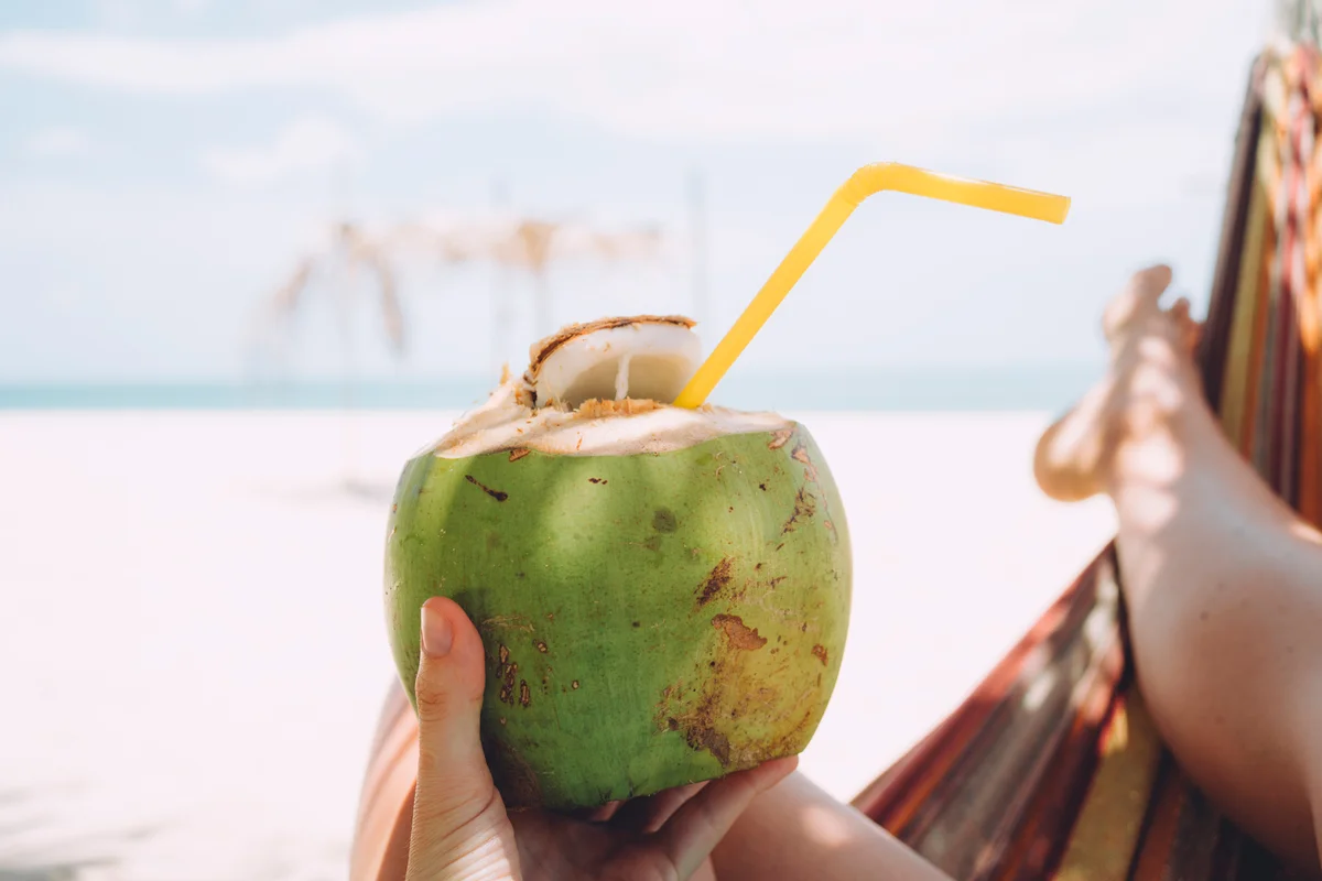 woman's hand holding fresh coconut